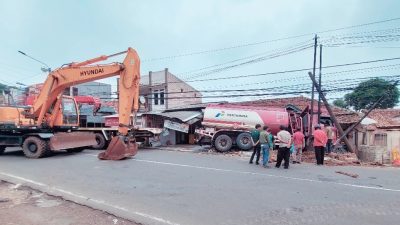 Foto detik-detik petugas gabungan saat melakukan evakuasi kendaraan truk pertamina yang nyungsep menabrak ruko di Pandeglang (Katakita.co)